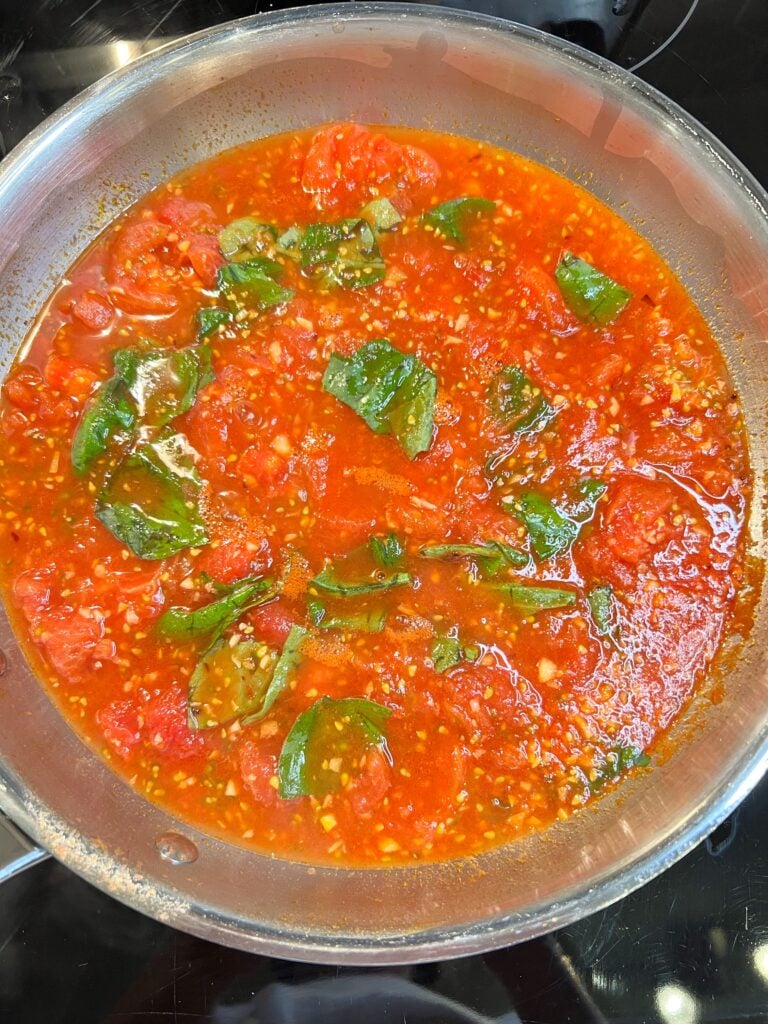 Fresh tomato sauce simmering with fresh torn basil.