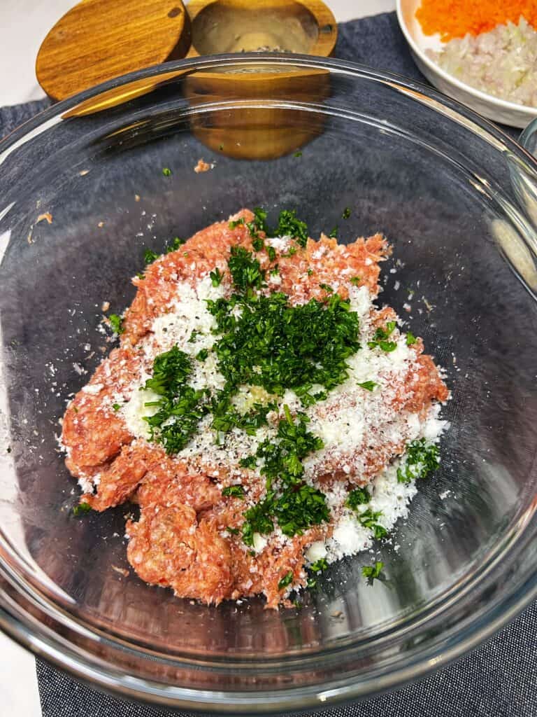 Meatball ingredients in a glass bowl for meatball soup.