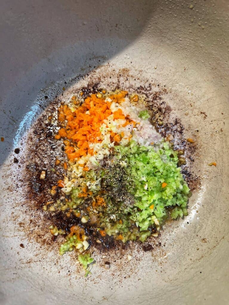 Minced celery, onions, carrots and garlic sautéing in a deep pot.