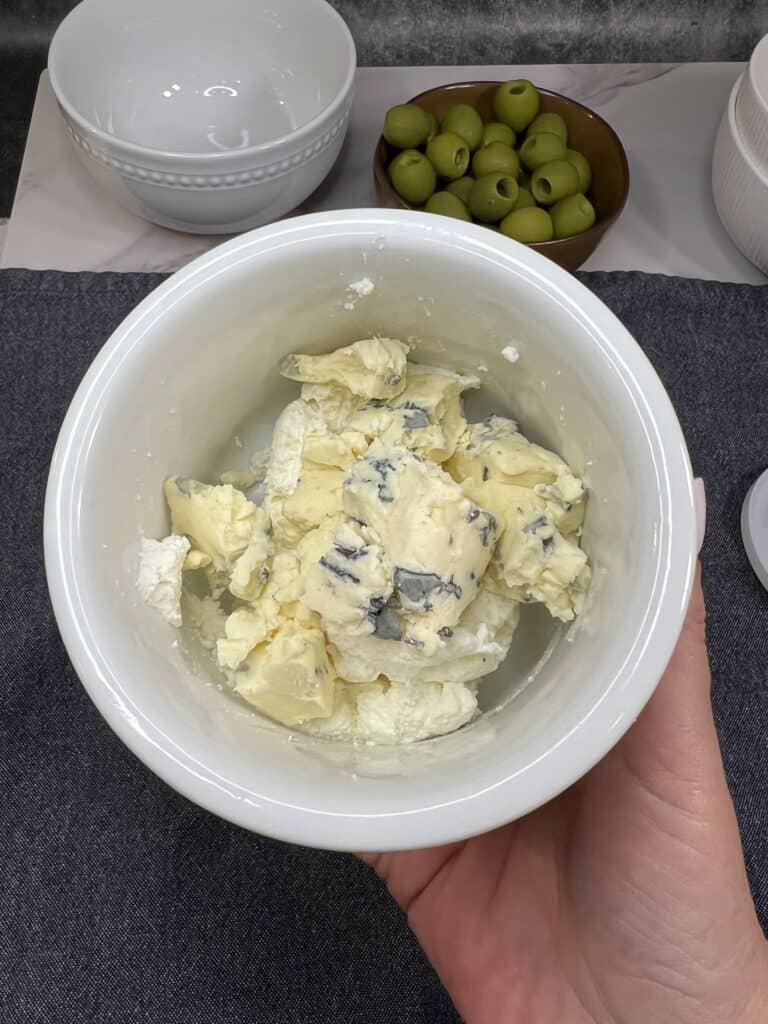 A white bowl filled with ricotta cheese and crumbled blue cheese.