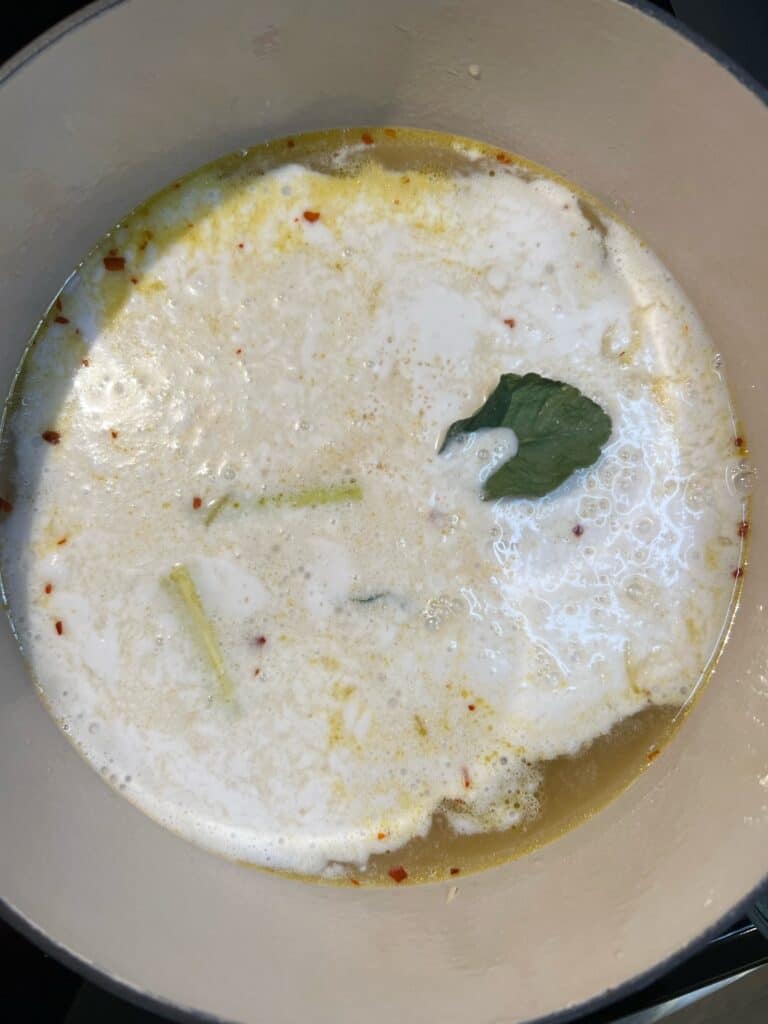 Broth for coconut soup with lime leaves.