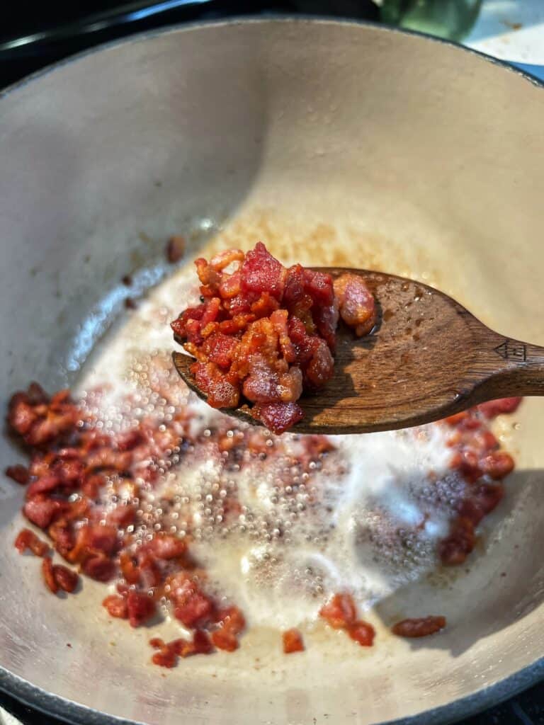 A wooden spoonful of crisp, diced bacon.