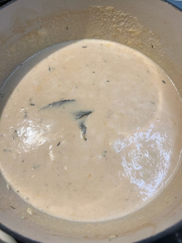 Heavy cream added to a pot with simmered shrimp stock.