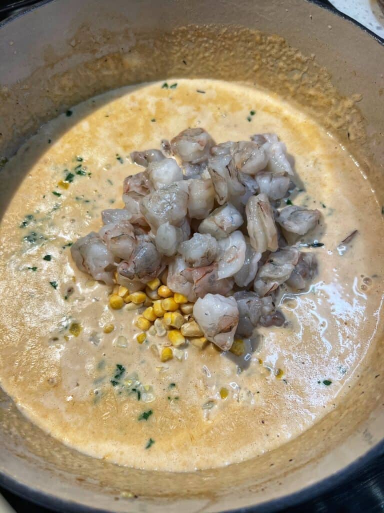 Fresh parsley, frozen corn and bite-sized raw shrimp added to chowder base for shrimp chowder.