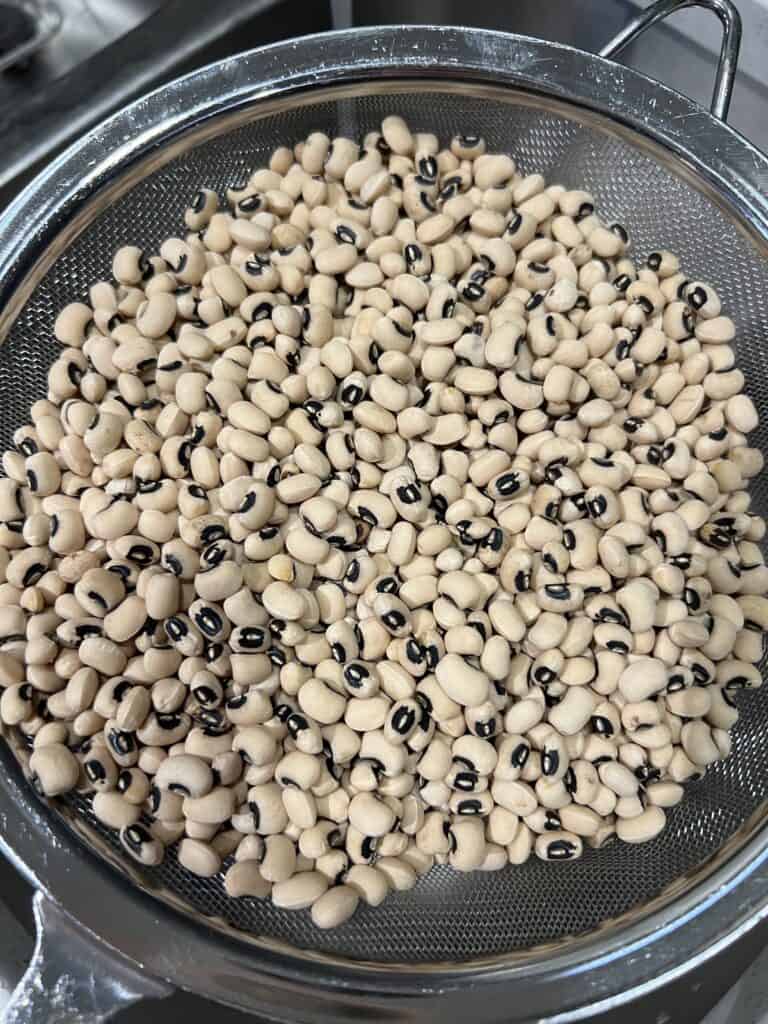 Black eyed peas in a mesh strainer.