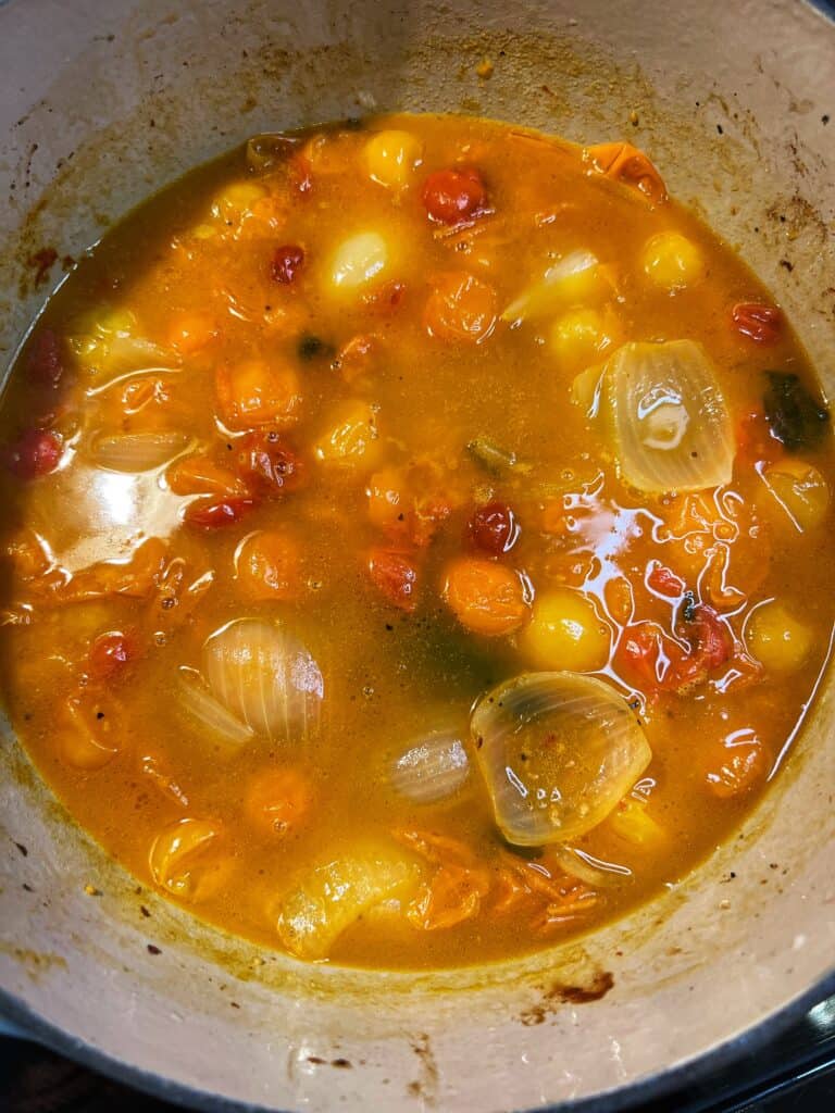 Tomatoes and vegetables roasted in an enameled cast iron pot.