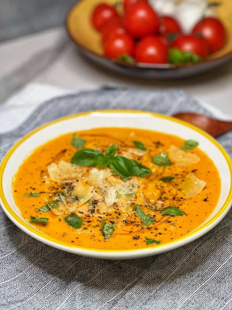 A white bowl with yellow trimmed filled with Roasted Tomato Basil Soup with Rice