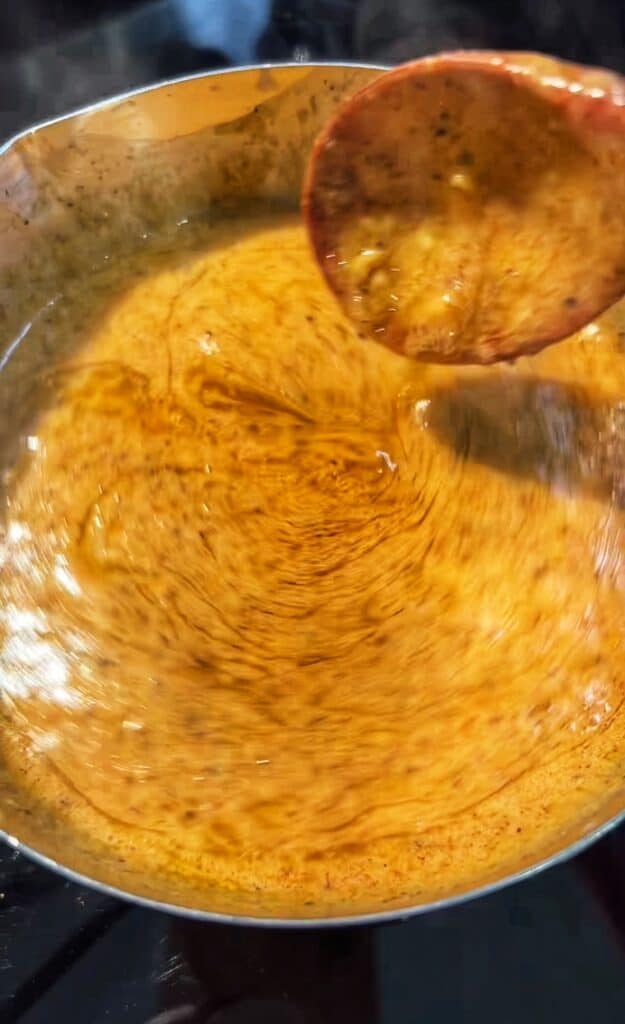 Garlic butter sauce in a stainless steel pot for a seafood boil.