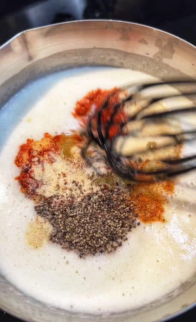 Mixing spices into a pot of melted butter.