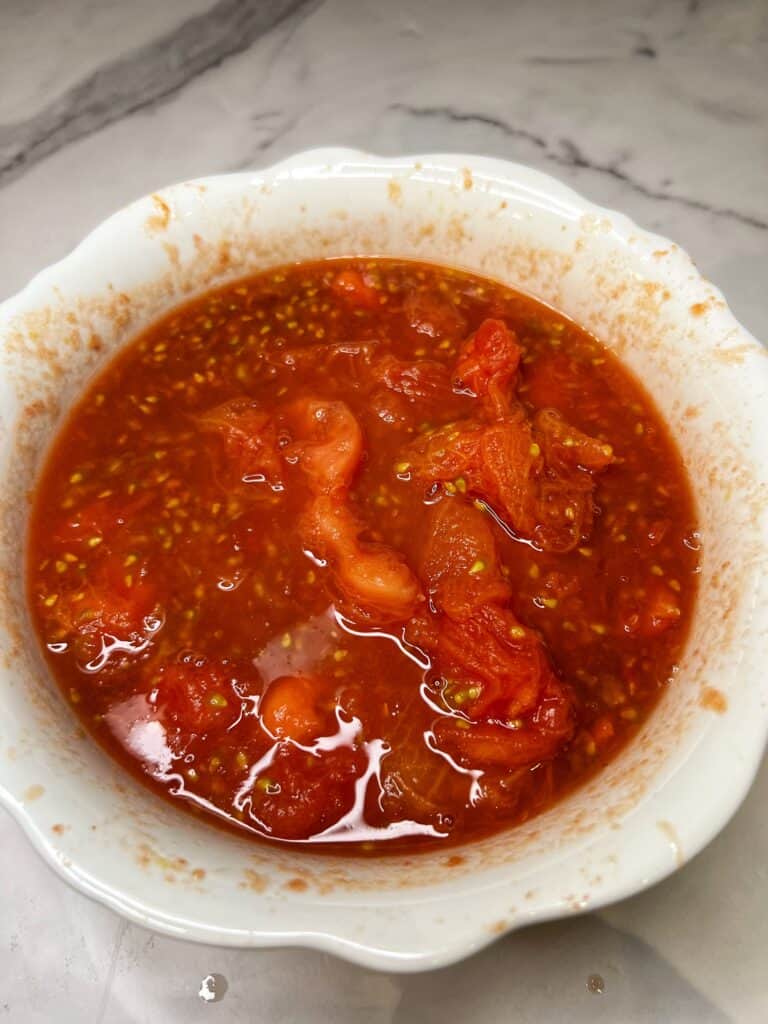 A white bowl of crushed Campari tomatoes.