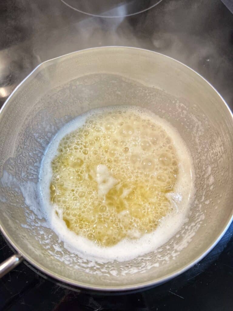 Lemon garlic butter sauce simmering in a small stainless steel pot.