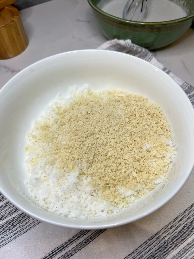 Shredded coconut and panko sitting in a white bowl.