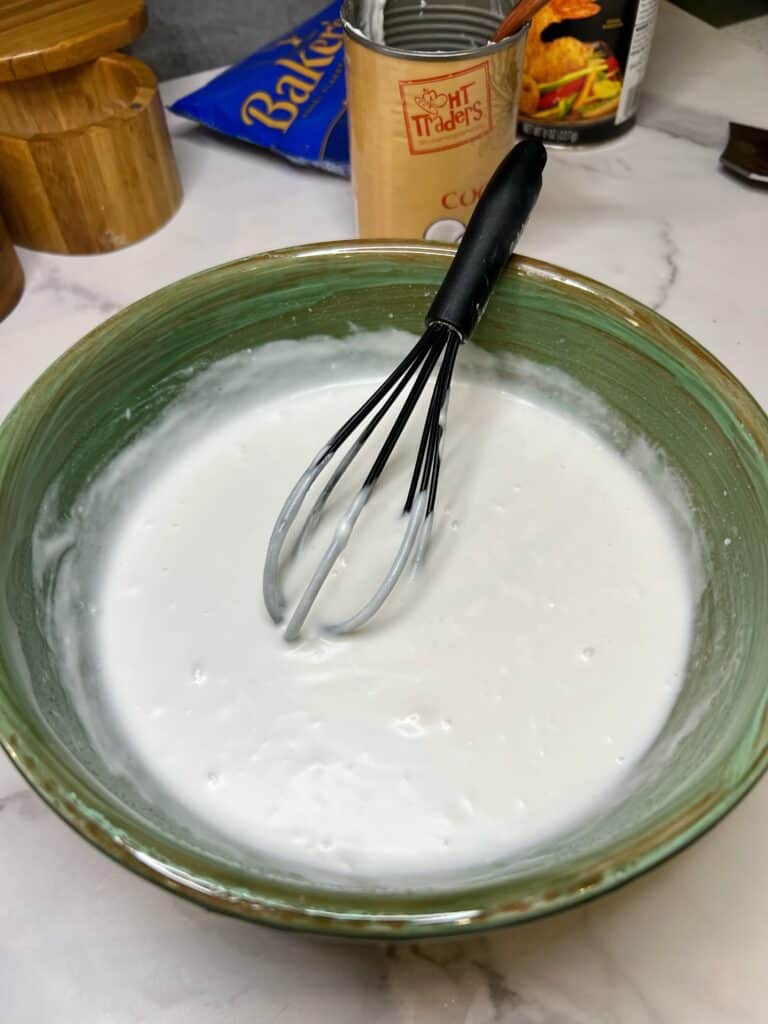 A can of coconut milk with cream in a green bowl.