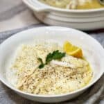 A white bowl filled with steamed rice and oven poached orange roughy.