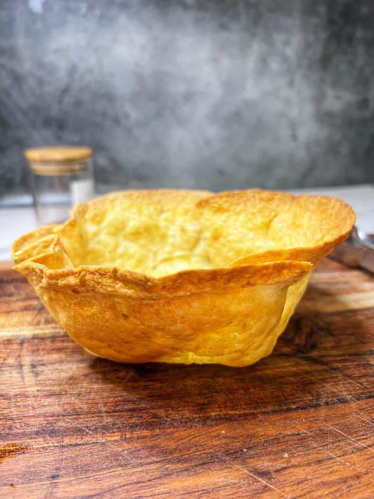 Side view of a homemade, baked taco bowl made out of a large flour tortilla.