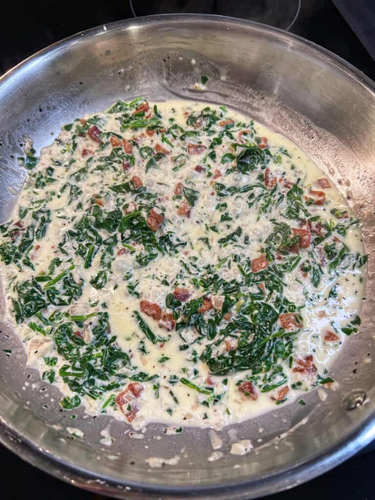 Spinach cream filling for Rockefeller Style Grilled Oysters in a stainless steel pan.