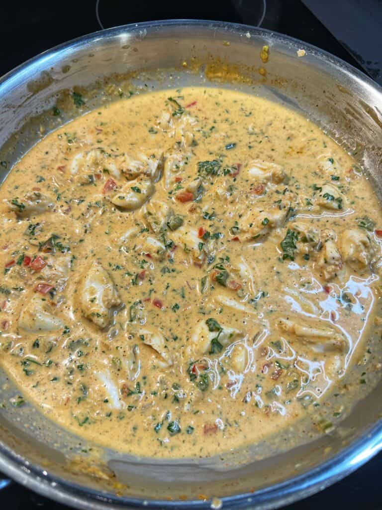 A pan of Creole crab sauce. Jumbo lump crab meat was added with fresh parsley to a creamy Creole sauce.