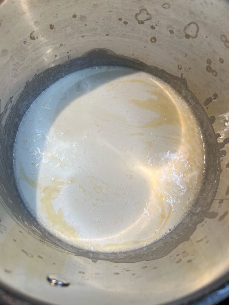 Heavy cream added to a saucepan of melted butter and flour.