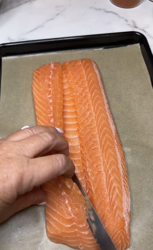 Cutting a flap on a salmon filet to butterfly.