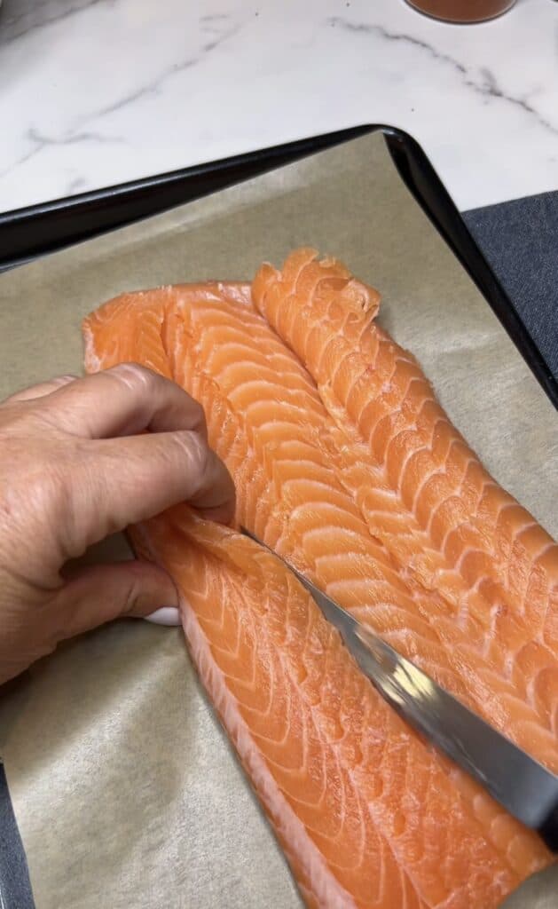 Cutting the other side of the salmon filet to create a flap.
