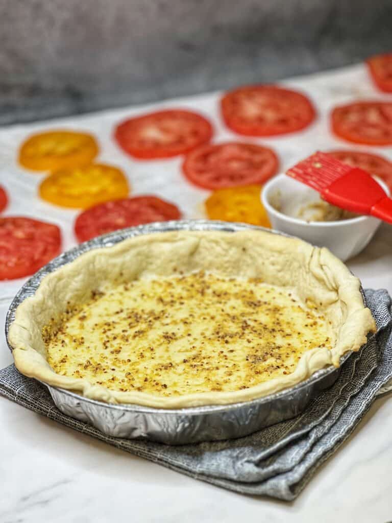 A par-baked pie crust that the inside has been brushed with a thin layer of stoneground mustard.