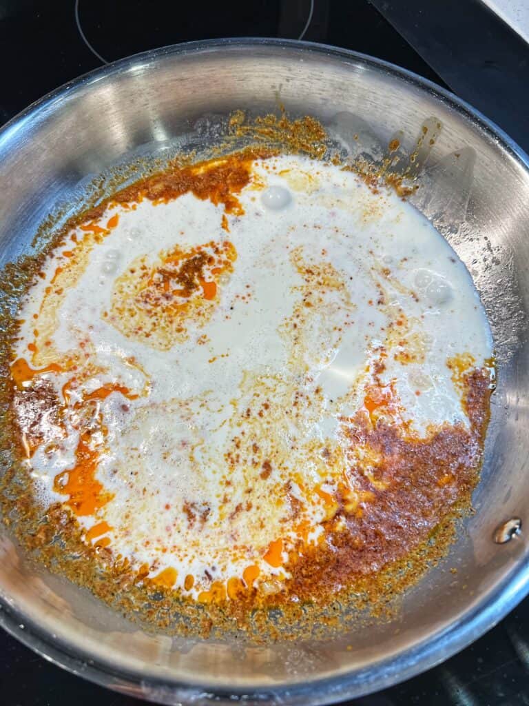 Heavy cream in a spicy white wine reduction for creamy Cajun sauce.