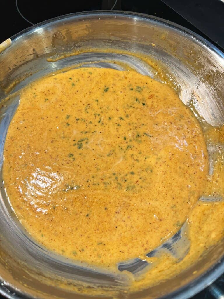 A creamy Cajun sauce in a stainless steel pan.