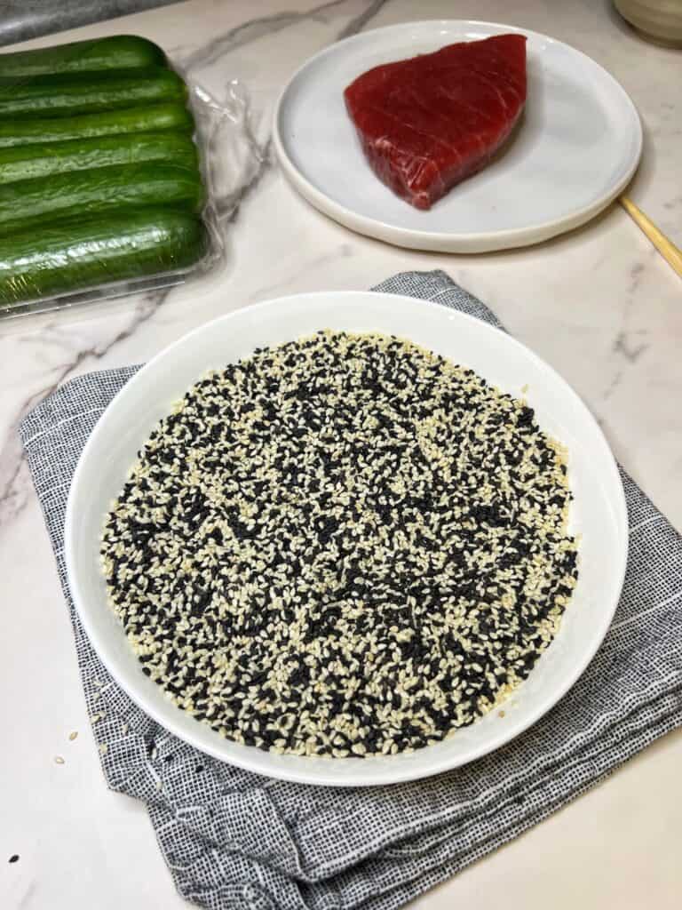 A shallow white bowl filled with mixed black and white sesame seeds.
