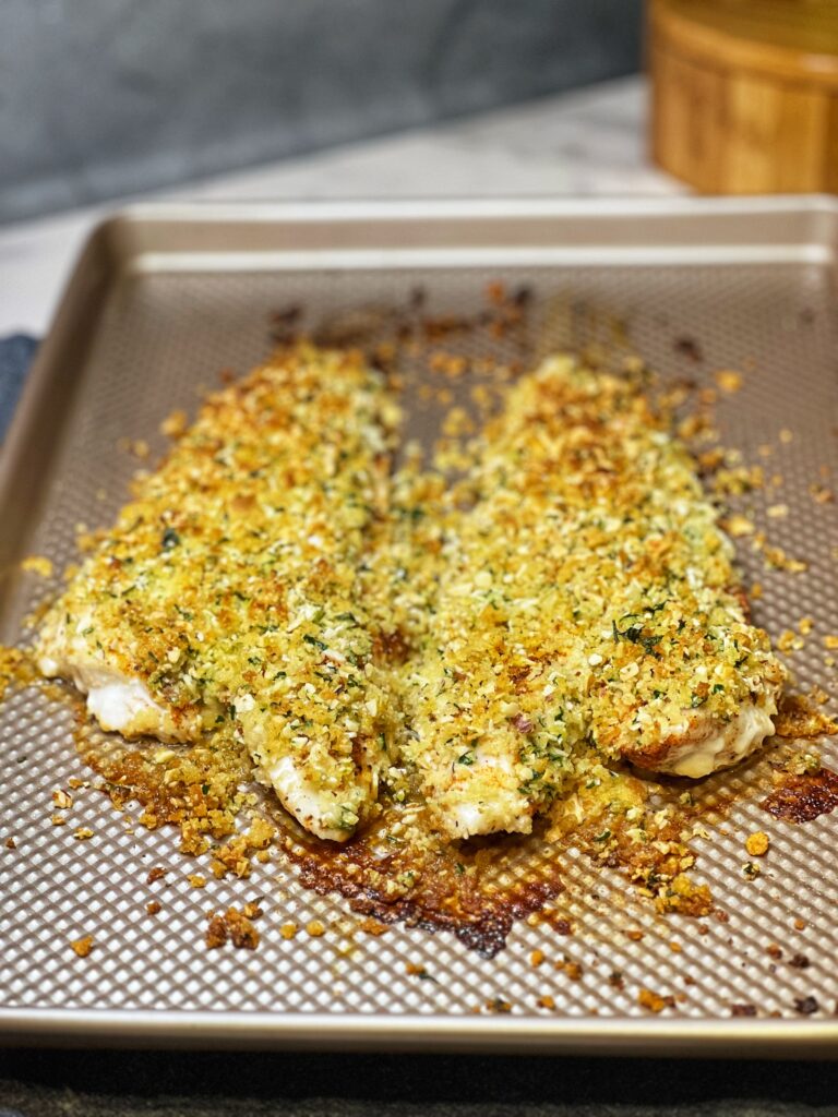 A sheet pan of Two Almond Crusted Baked Wolffish filets. The top of the filets are golden brown.