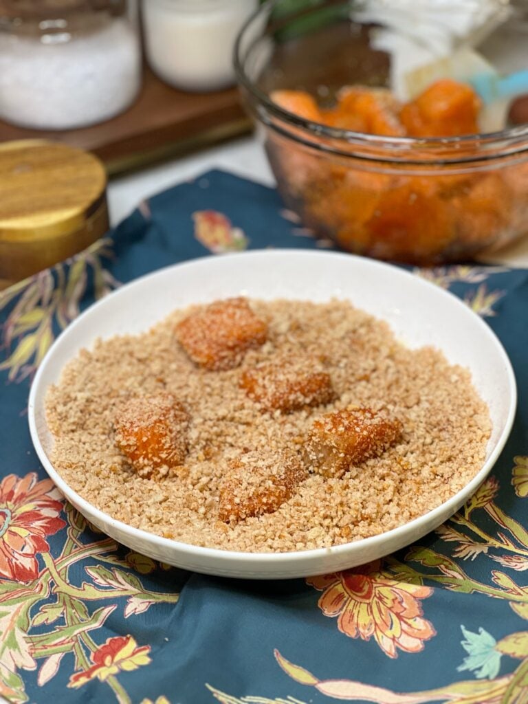 Salmon bites coated in panko breadcrumbs in a shallow white dish.