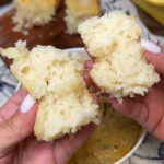 Me holding an opened, fluffy butter swim biscuit showing you the inside.
