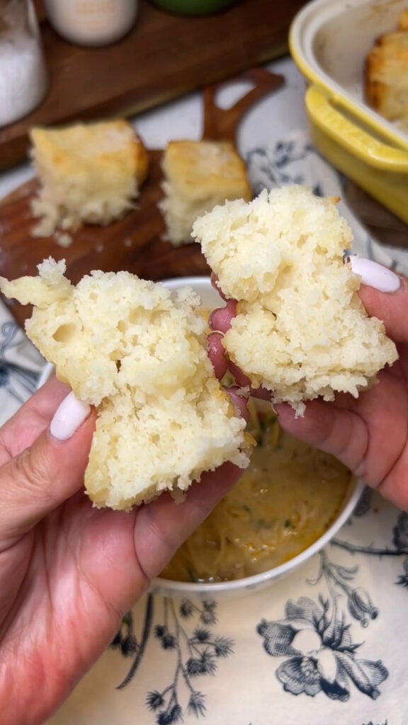Me holding an opened, fluffy butter swim biscuit showing you the inside.