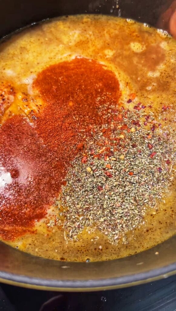 Seasonings added to a pot of soup.