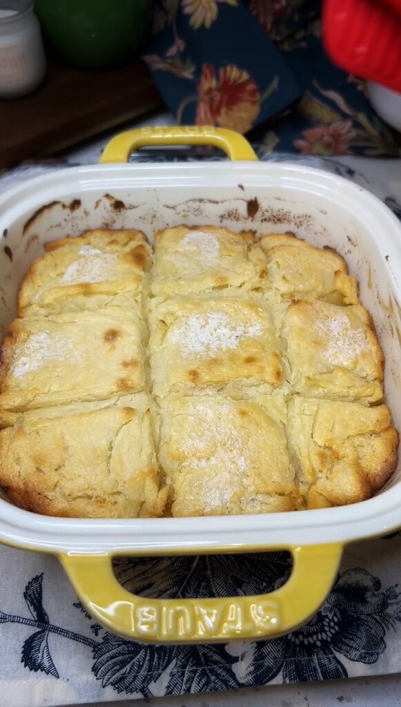 A casserole dish of baked, fluffy butter swim biscuits. There are 9 biscuits in the pan, that are golden brown.