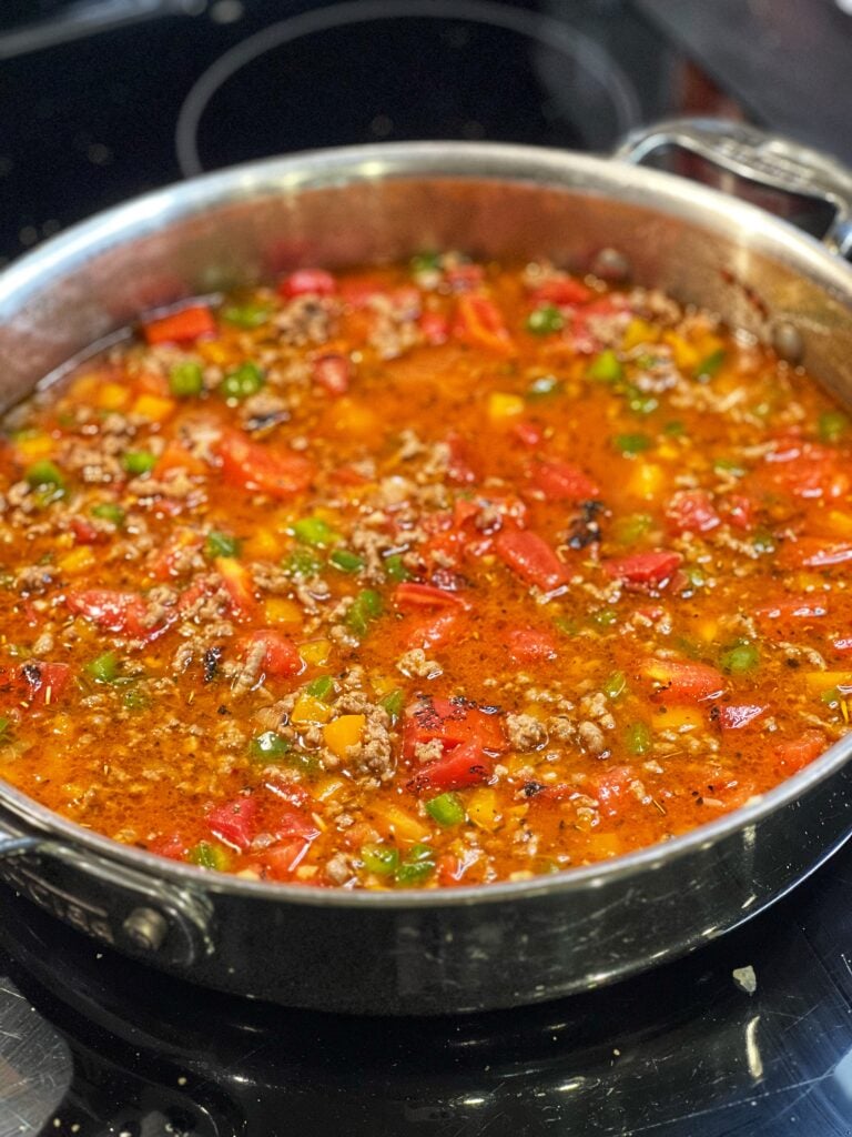 Ground beef, rice and bell peppers in a tomato sauce ready to simmer.