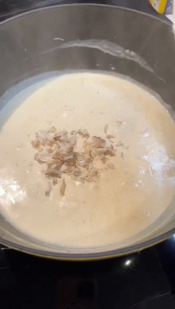 Adding the crabmeat into she crab soup.