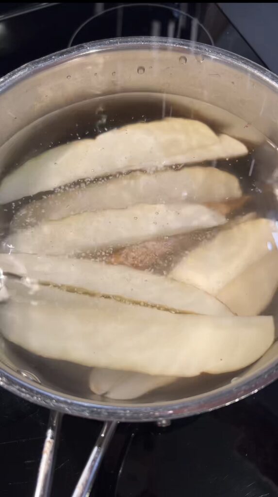 A pot filled with potato wedges.