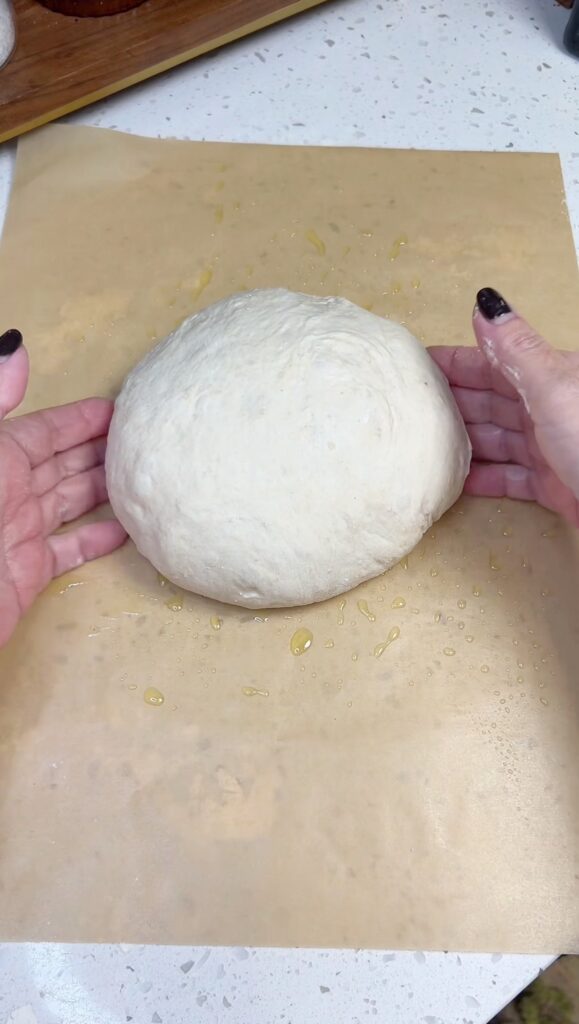 Me forming a smooth, round ball of down on a piece of parchment paper.