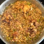 A stainless steel pan of Creamy Cajun Chicken and Rice. Boneless chicken thighs are seared and golden brown.