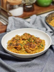 A bowl of creamy Cajun chicken and rice garnished with fresh parsley.