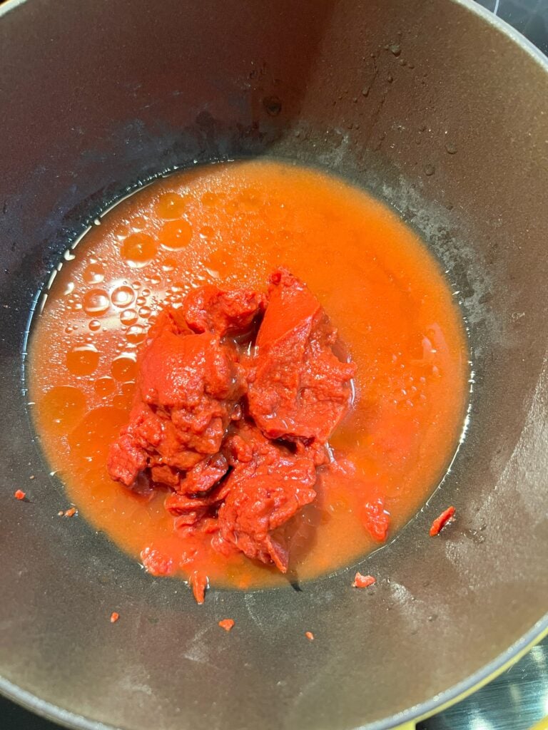 Tomato paste in a pot with a little bit of water.