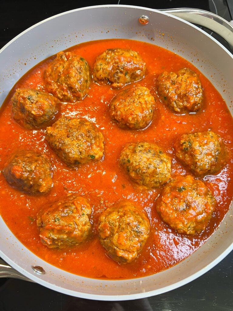 Meatballs in a marinara sauce. The meatballs are going to be used in a meatball salad with vinaigrette.
