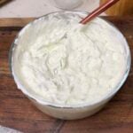 A bowl of creamy homemade tzatziki sauce. The sauce is white with cucumber.