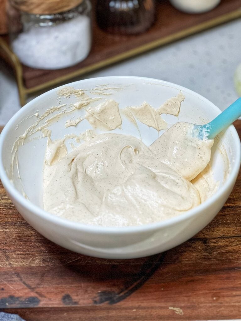 A white bowl filled with a white creamy base for creamy Vidalia onion dip.