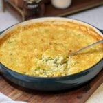 Cheesy Broccoli Rice Casserole shown with a spoonful of the rice coming out of the bluish green pan.